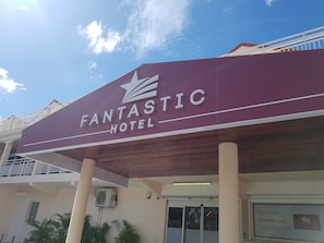 A maroon sign with "FANTASTIC HOTEL" and a star logo. - Fantastic Hotel (Marigot)