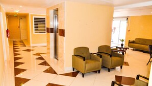 A lobby with a checkered floor, a reception desk, and seating areas. - Fantastic Hotel (Marigot)