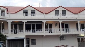 A multi-story building with a red roof, white exterior, and balconies. - Fantastic Hotel (Marigot)