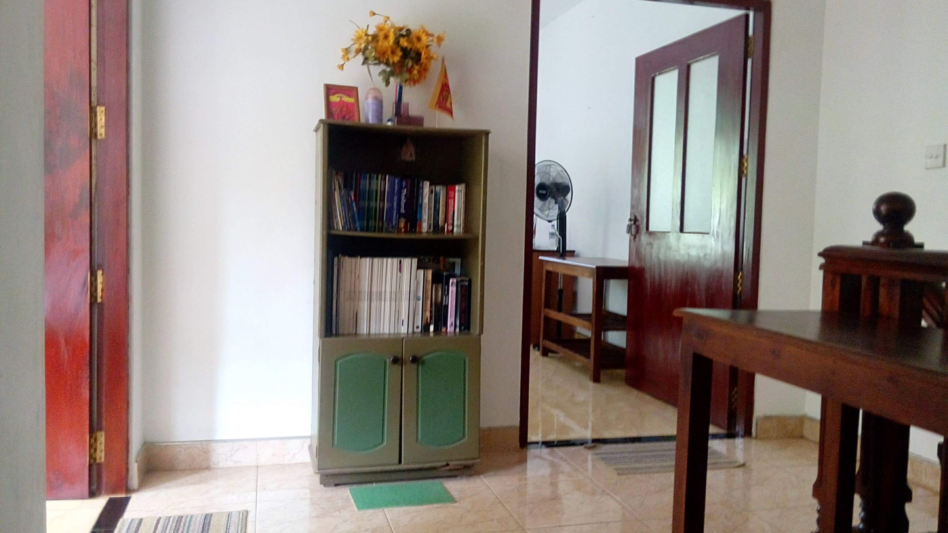 A room with a bookshelf, a wooden table, and a door.