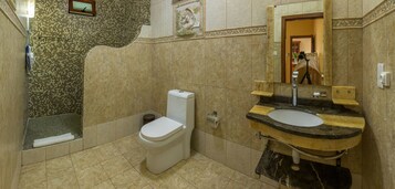 A bathroom with a shower, toilet, and sink.