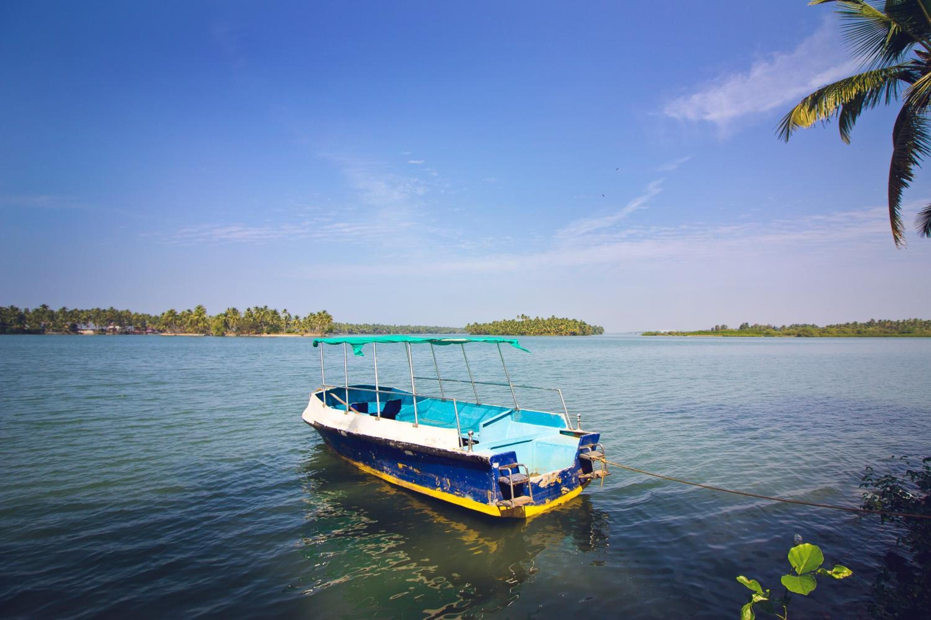 Un barco sobre aguas tranquilas, con cielo despejado y tierra a lo lejos.