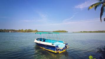 Un barco sobre aguas tranquilas, con cielo despejado y tierra a lo lejos.