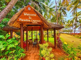 Una estructura de madera con techo de paja que dice: 'Bienvenidos a Paradise Lagoon'.