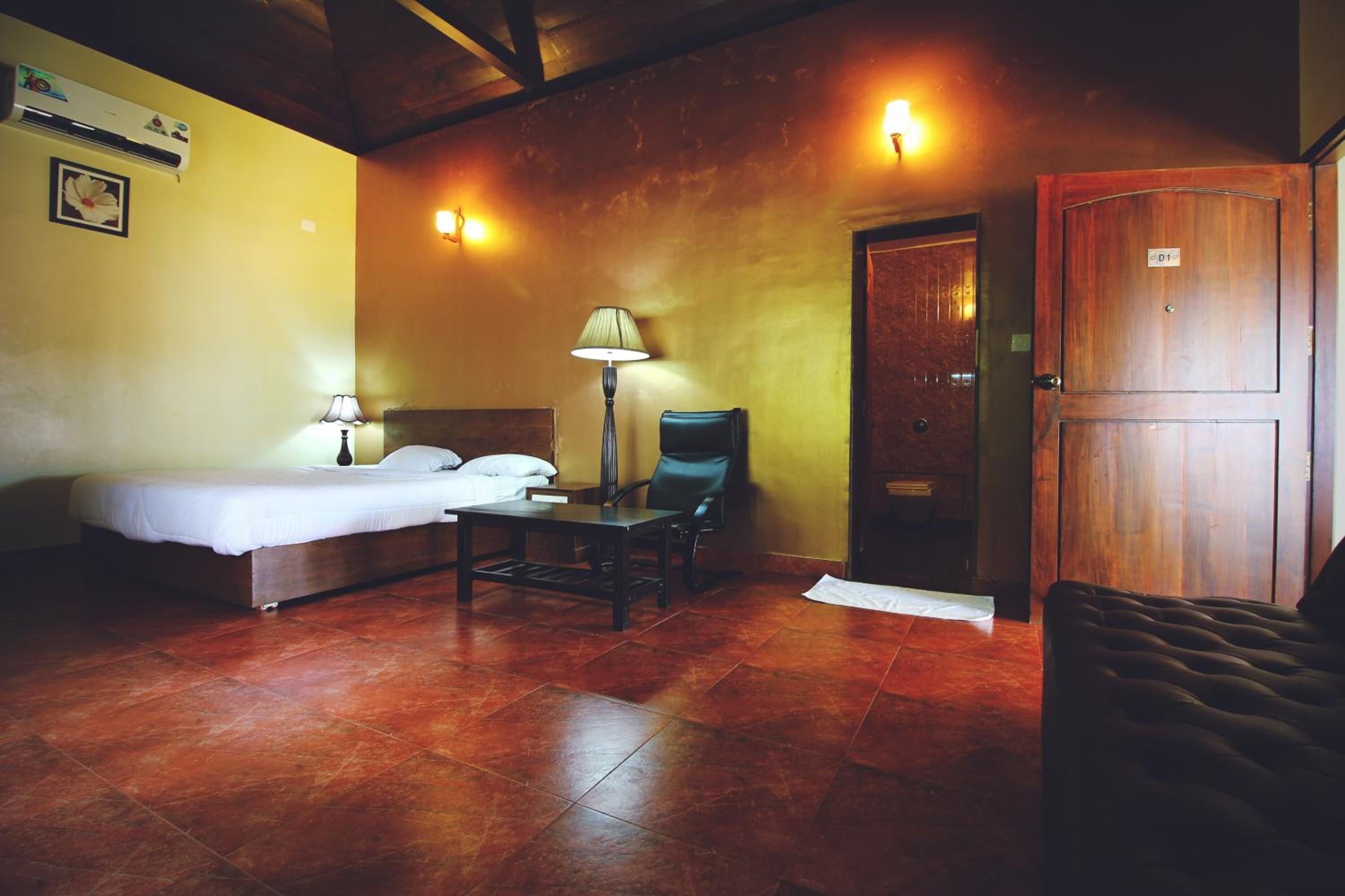 A room with a bed, a desk, a chair, and a wardrobe.