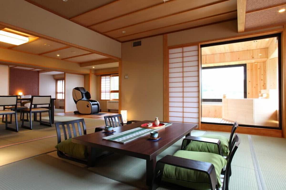 Una habitación japonesa tradicional con suelo de tatami, una mesa baja de madera y puertas correderas shoji.