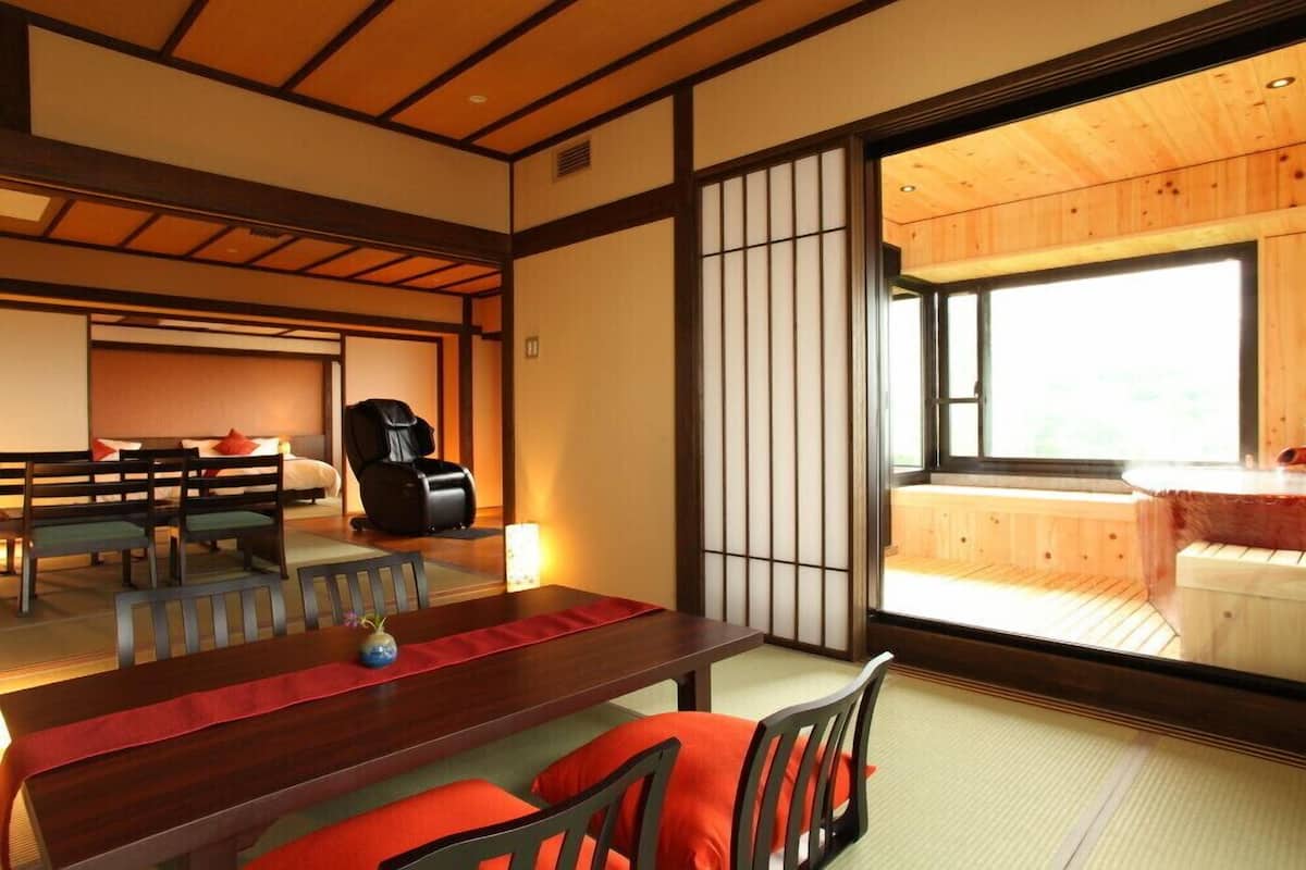 Una habitación tradicional japonesa con suelo de tatami, una mesa de madera baja y un divisor corredizo shoji.