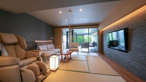 Ein modernes Wohnzimmer mit Massagesessel, Sofa und Tatami-Matten.