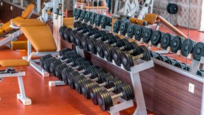A gym with rows of dumbbells and benches.