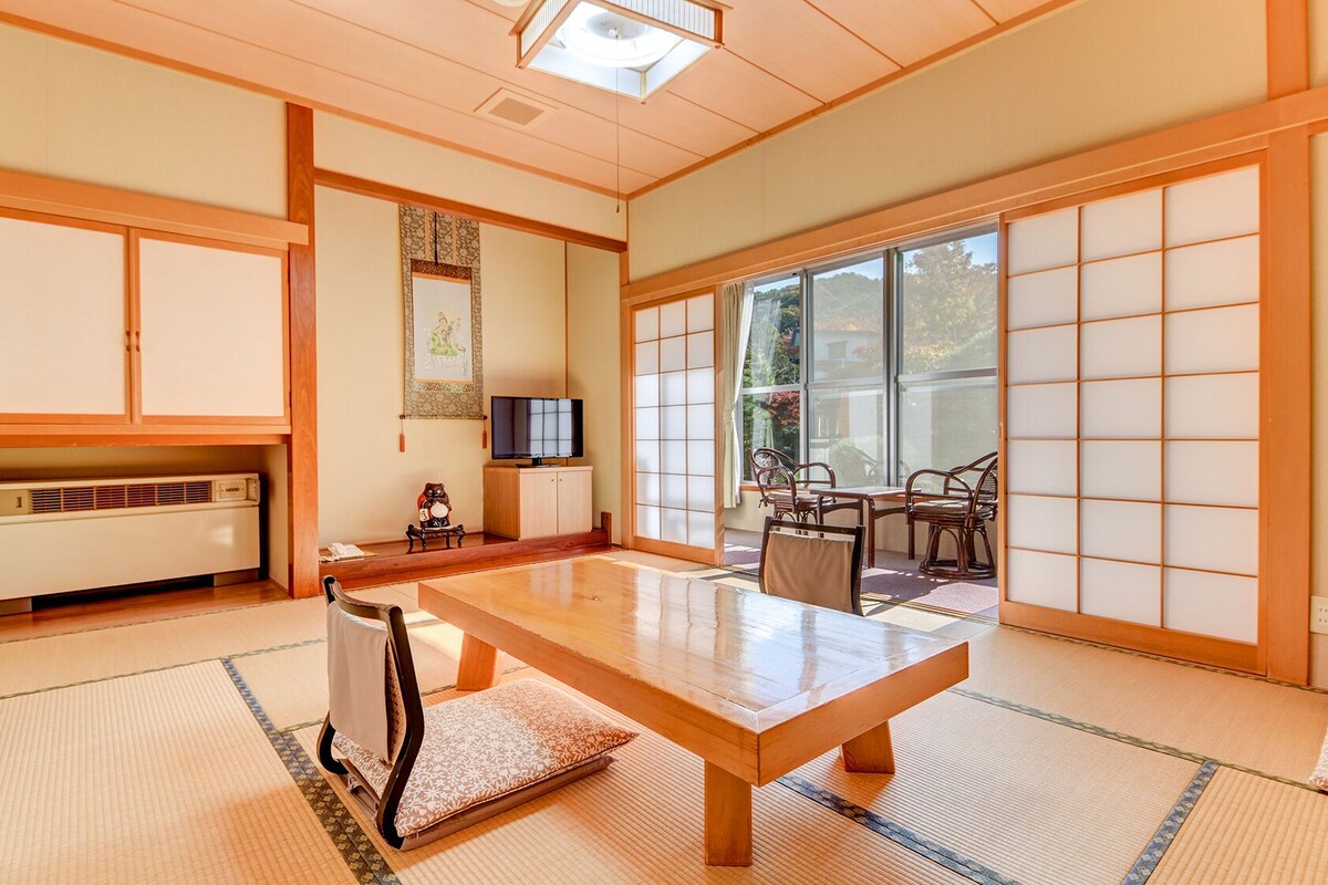 A traditional Japanese room with tatami flooring, a low table, and sliding doors.