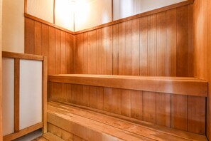 A wooden sauna with benches and a light fixture.