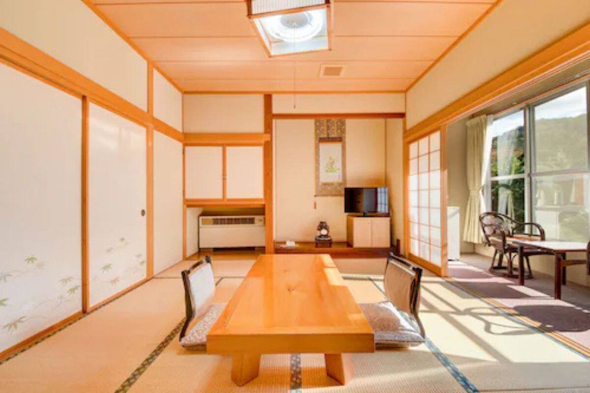 Una habitació tradicional japonesa amb fons de tatami, una taula baixa i portes corredisses.