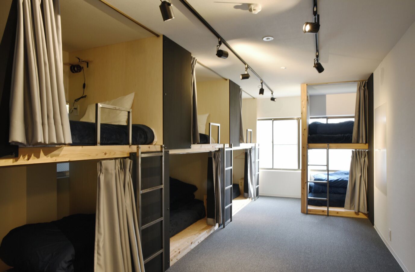 Un dormitorio con literas, una ventana y una lámpara en el techo.