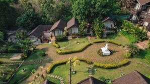 A resort with multiple bungalow-style buildings surrounded by well-maintained gardens and pathways. - Stone Wood Resort (Mandrem)