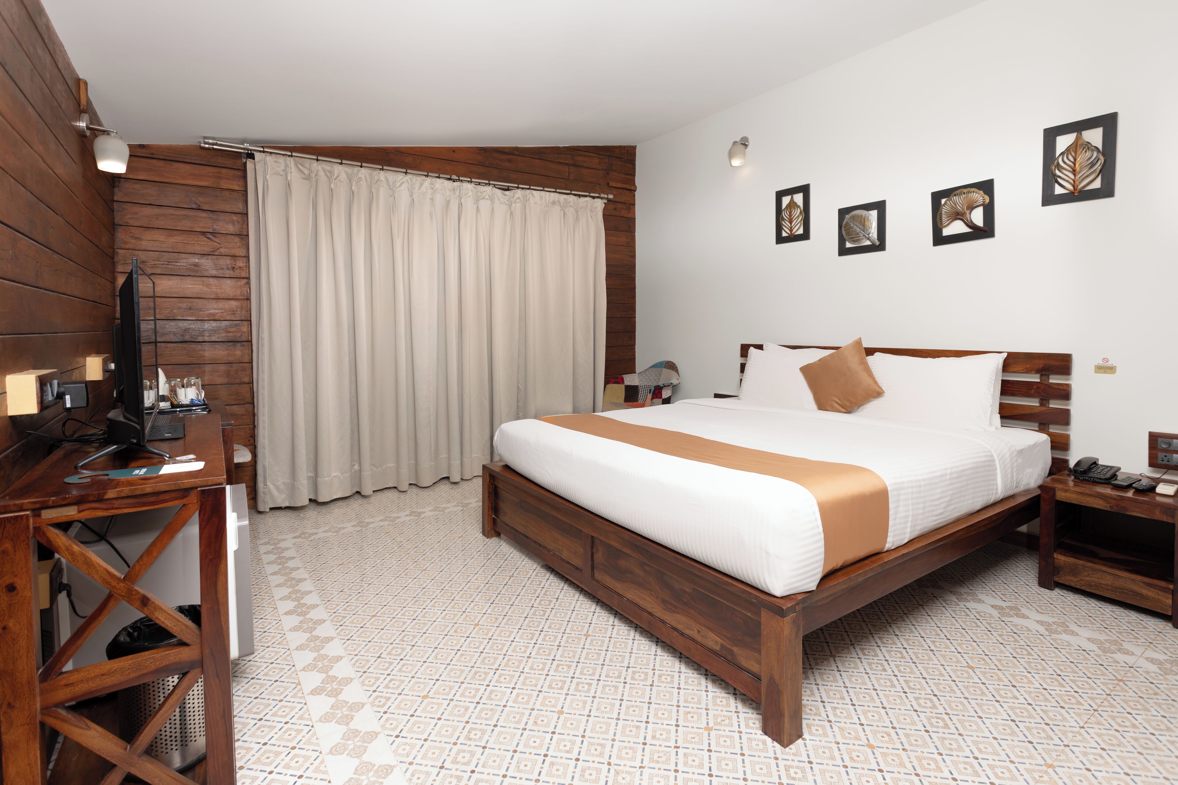 Un dormitorio con cama de madera, un escritorio con computadora y una ventana con cortinas.