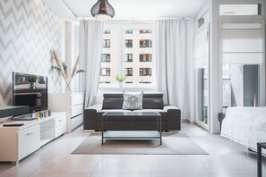 Ein modernes Wohnzimmer mit Sofa, Couchtisch und Fernseher.
