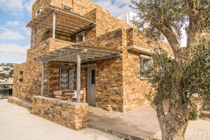 A stone building with a balcony and a tree in front.