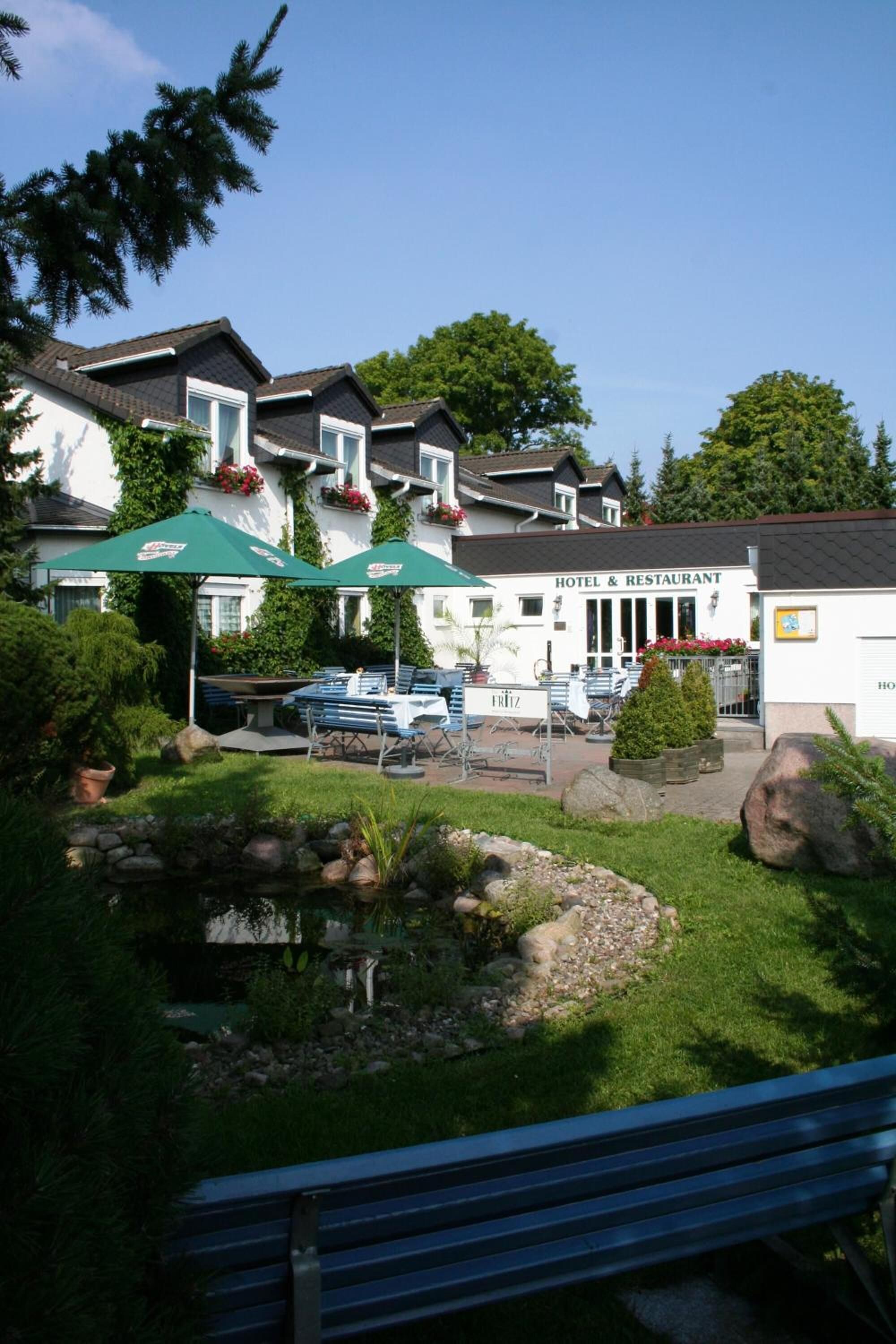 A hotel with outdoor seating and a garden area.