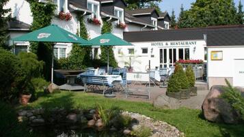 A hotel with outdoor seating and a garden area.
