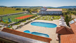 A swimming pool, tennis court, and a large building with a red roof. - Hotel Europa Kokeltal (Albesti)