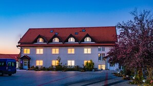 A large, multi-story building with a red-tiled roof and multiple windows. - Hotel Europa Kokeltal (Albesti)