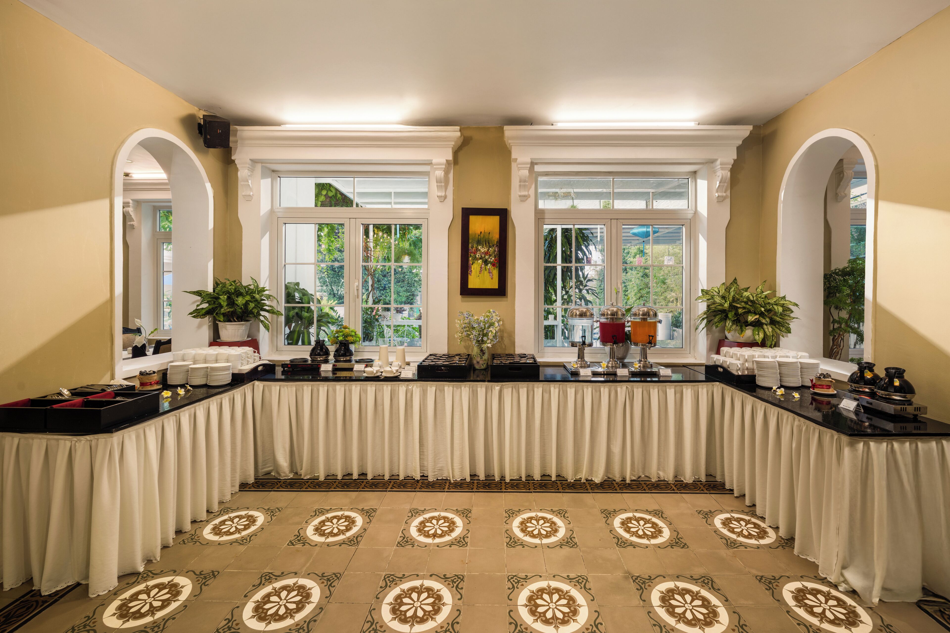 A conference room with a long table, white drapes, and patterned carpet.