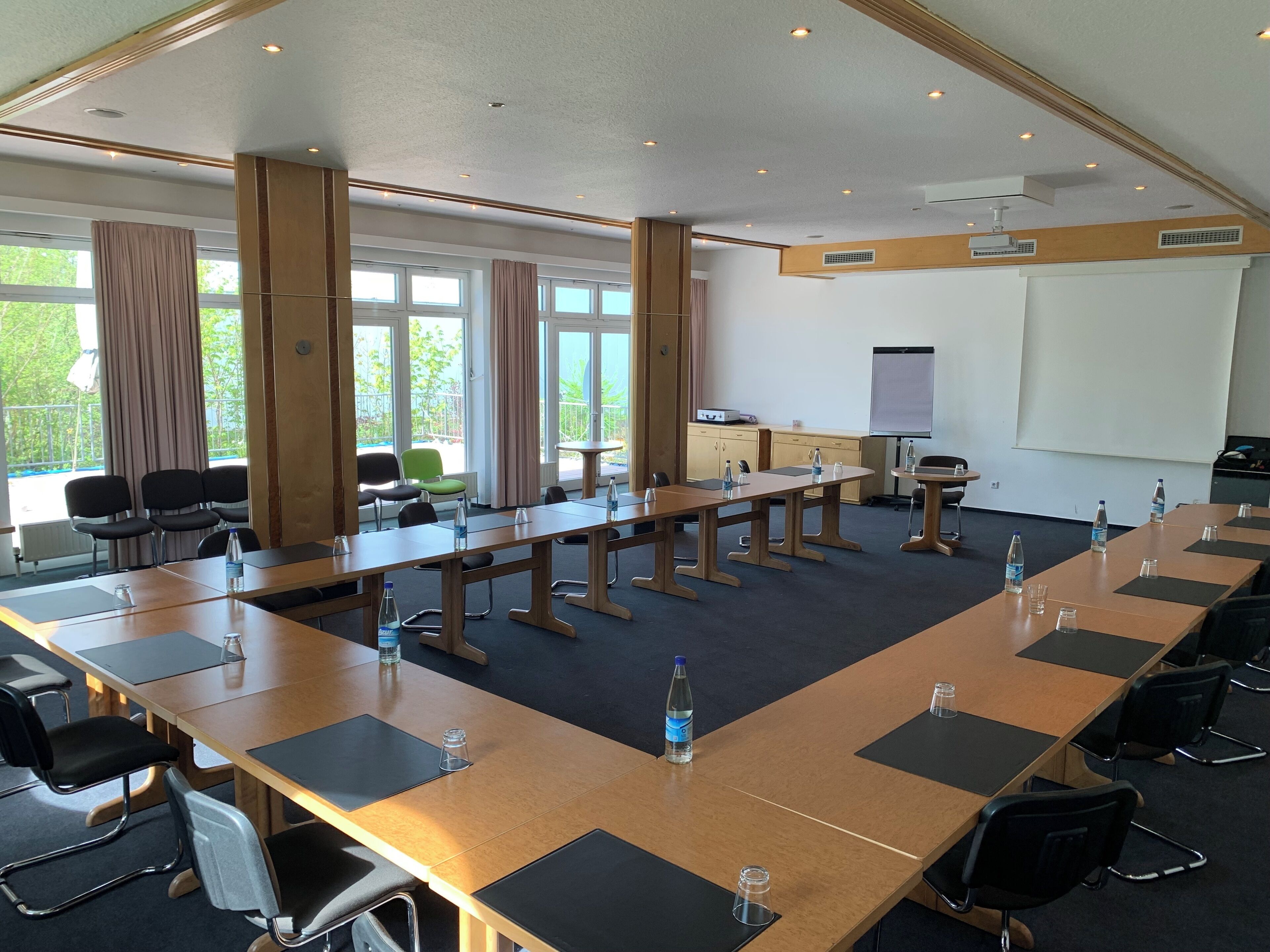 A conference room with long tables, chairs, and a whiteboard.