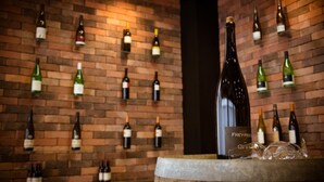 A wine rack with various bottles against a brick wall. - Rheinhessen Inn (Woerrstadt)