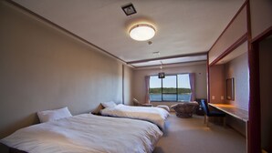 A hotel room with two beds, a desk, and a view of the sea. - Hotel Hana (Shima)