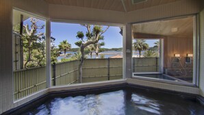 A hot tub with a view of a tree and a body of water. - Hotel Hana (Shima)