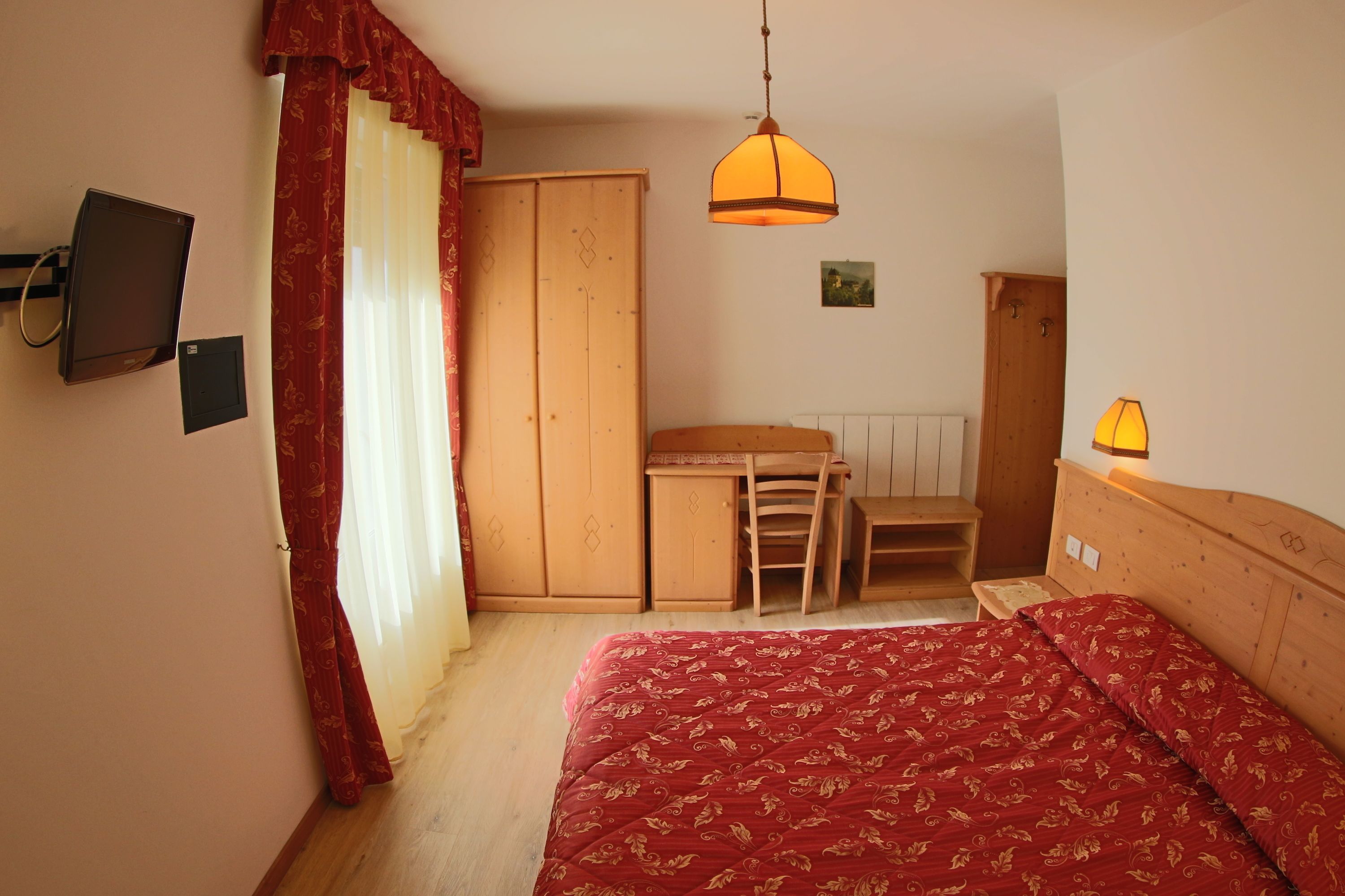 Un dormitorio con cama, escritorio, silla y armario.