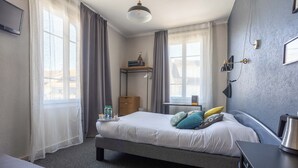 Habitación de hotel ordenada con cama, mesita de noche y escritorio con silla.