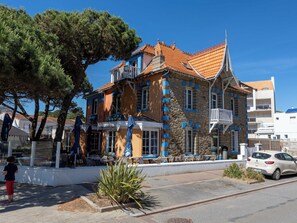 A building with a stone facade, multiple balconies, and a tiled roof. - La Villa Rose Marie (Saint-Brevin-les-Pins)