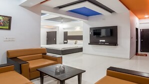 Une chambre d’hôtel moderne, équipée d’un lit, d’un canapé et d’une télévision.