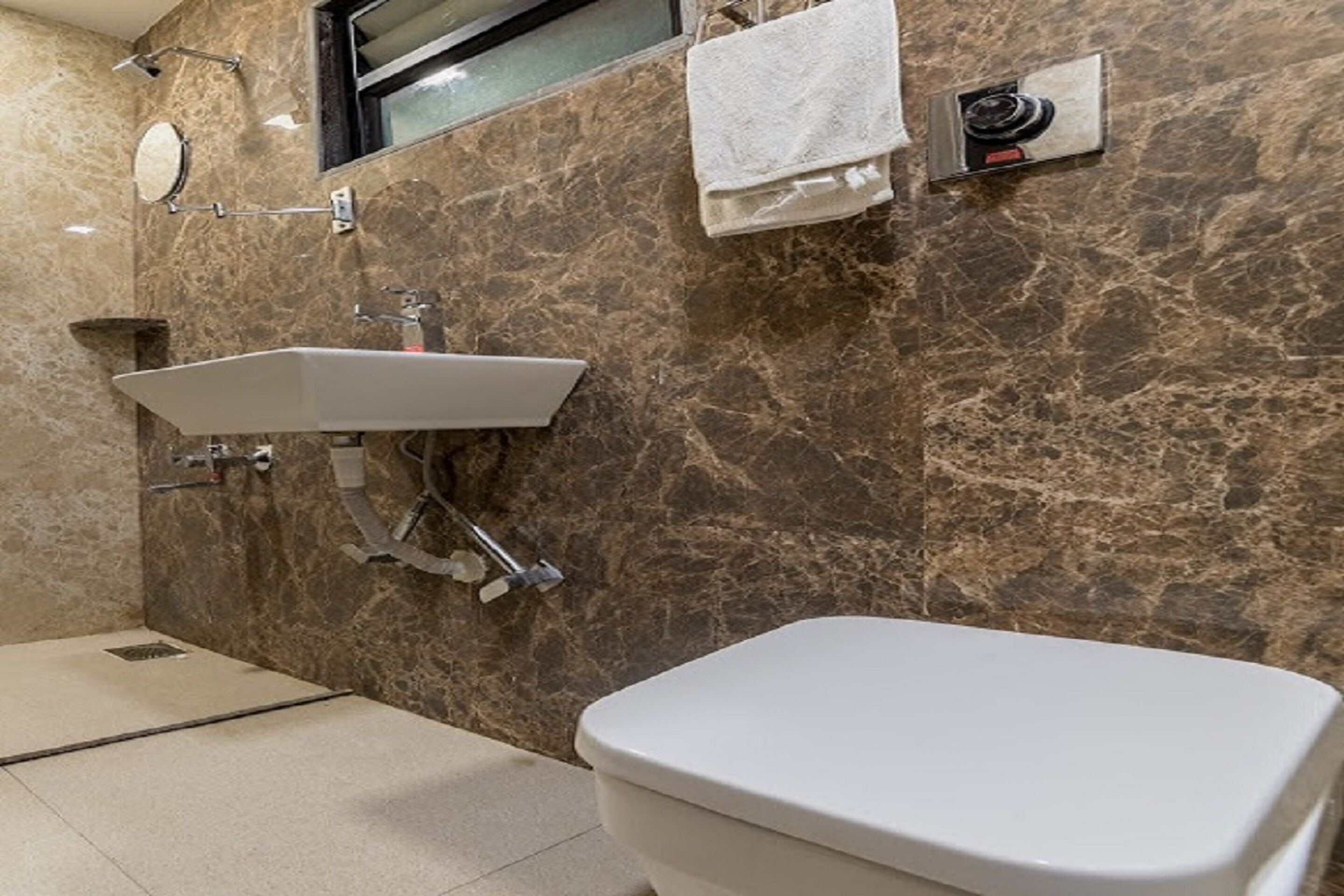 A bathroom with a white sink, a toilet, and a shower head.