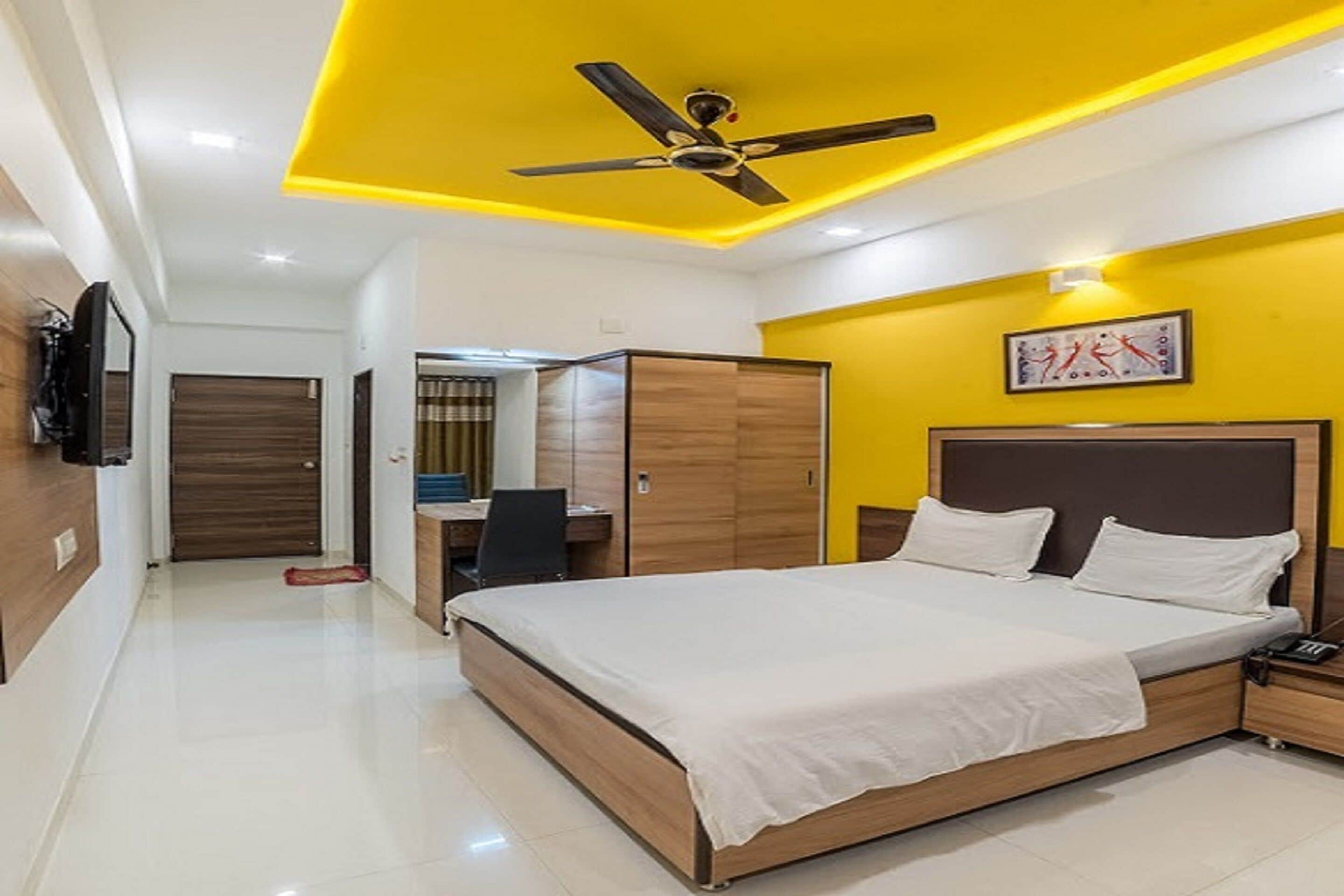 A modern bedroom with a bed, a desk, and a wardrobe.