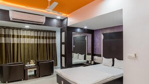 Une chambre moderne avec un grand lit, un ventilateur de plafond et un appareil de climatisation.