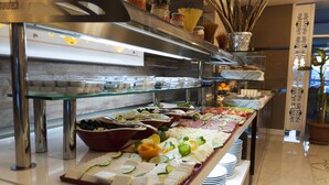 Un bufé con diferentes alimentos y utensilios.