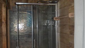 A wooden cabin with a glass-enclosed shower area. - Kalsee Ecolodge (Lumle)