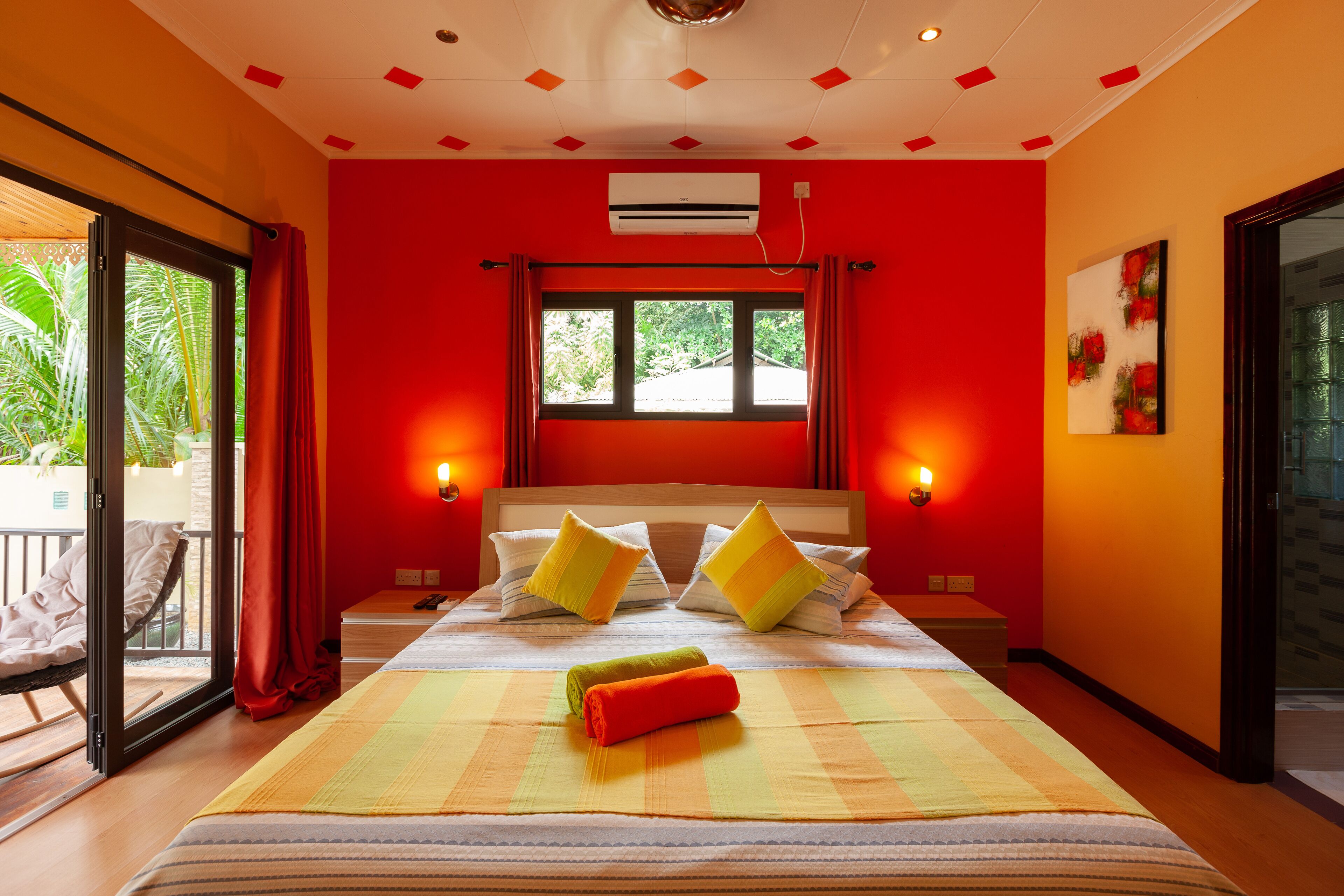 Habitación de hotel con una cama grande, dos almohadas, una ventana y un balcón con una silla.