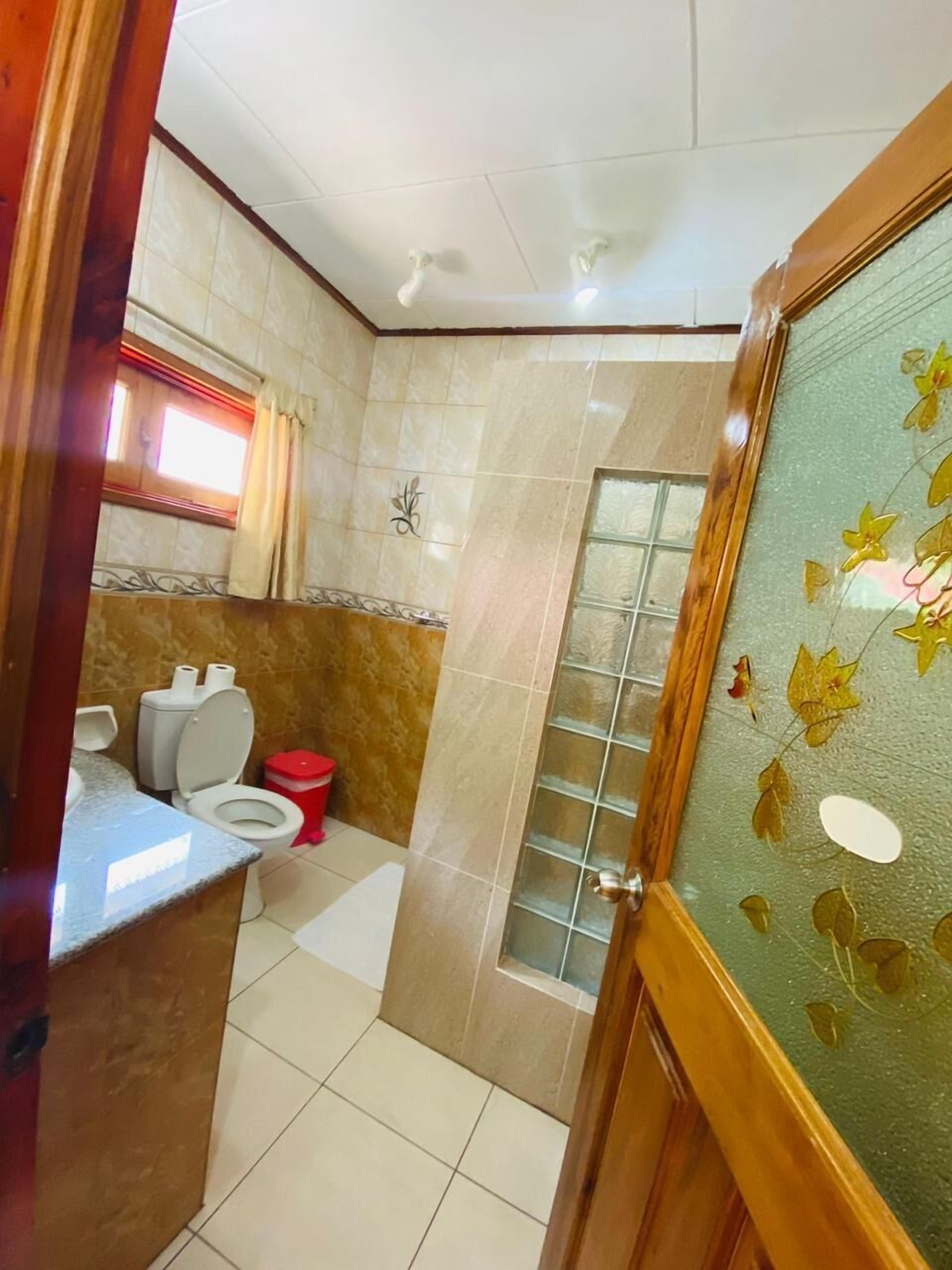 A bathroom with a toilet, a sink, and a shower area.