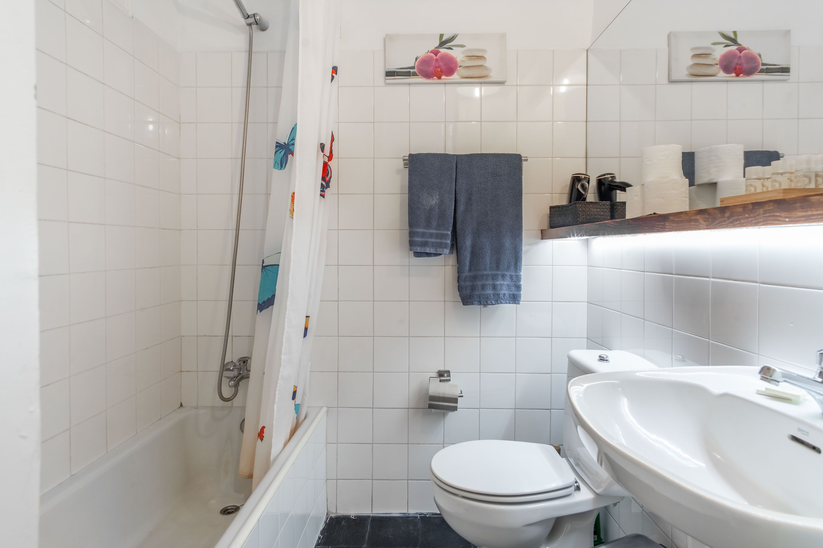 Een badkamer met een bad, toilet en wastafel.