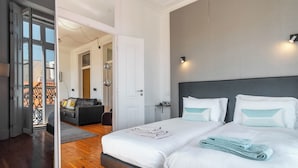 Una habitación de hotel con una cama grande, un sofá y vistas a un balcón.