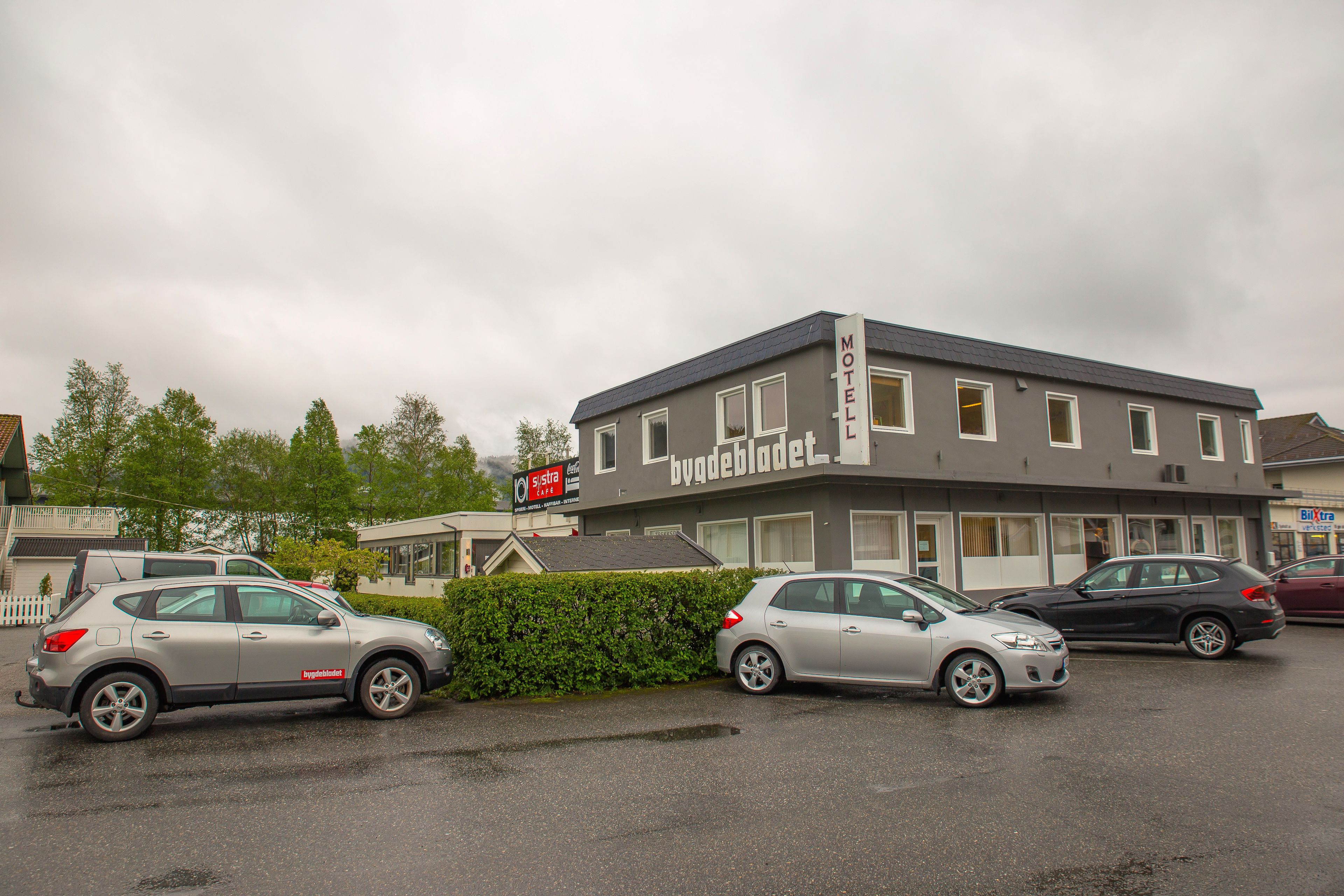 Ein Motel mit grauer Fassade, zahlreichen Fenstern und einem Schild, das es als Motel kennzeichnet.