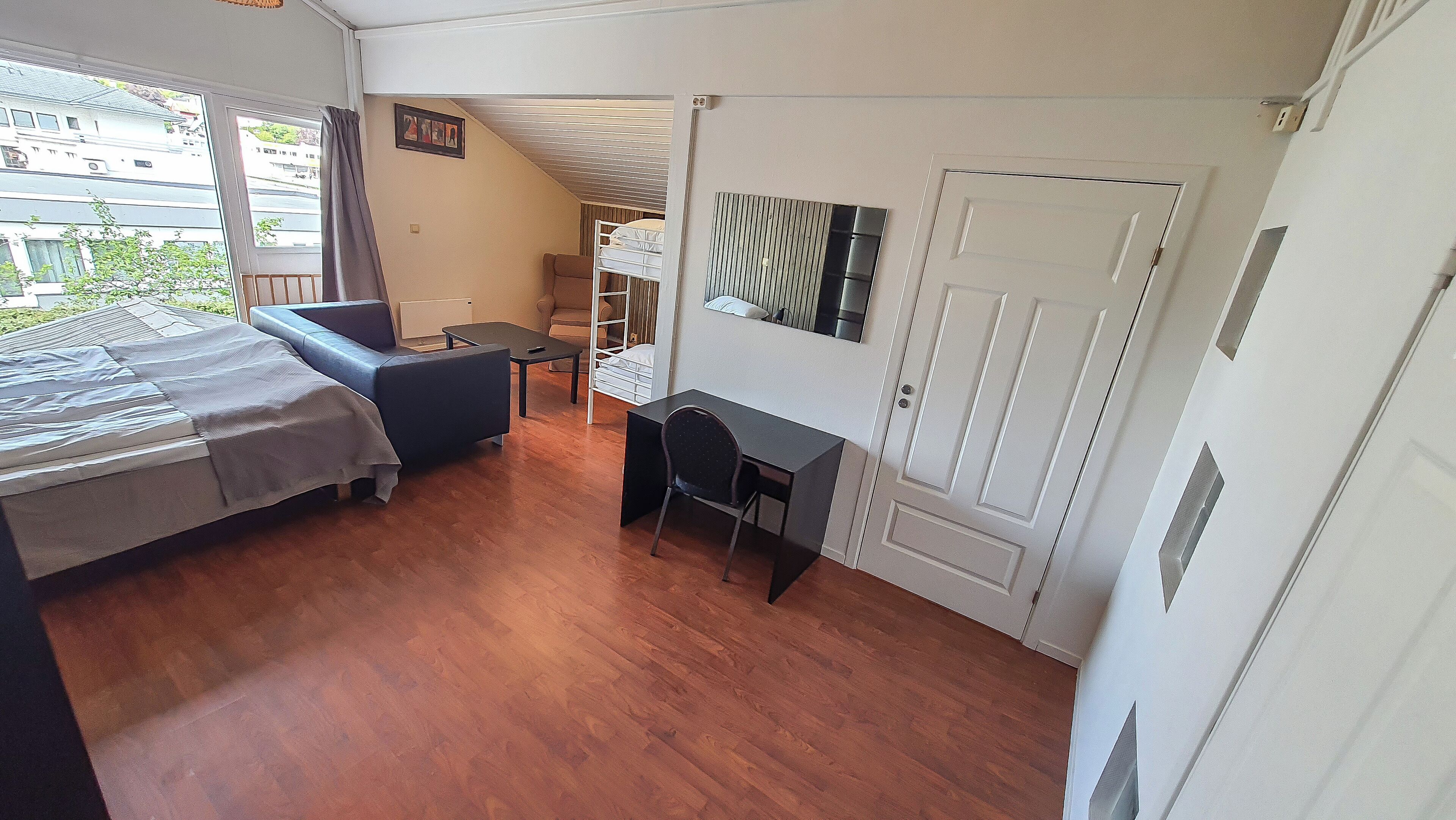 Une chambre à coucher avec un lit, un bureau, une chaise et une armoire.