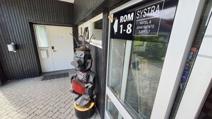 A hotel entrance with a sign indicating rooms 1-8, a metal sculpture, and a door with a window. - Systra Hotel Apartments Sjøholt (Ålesund)