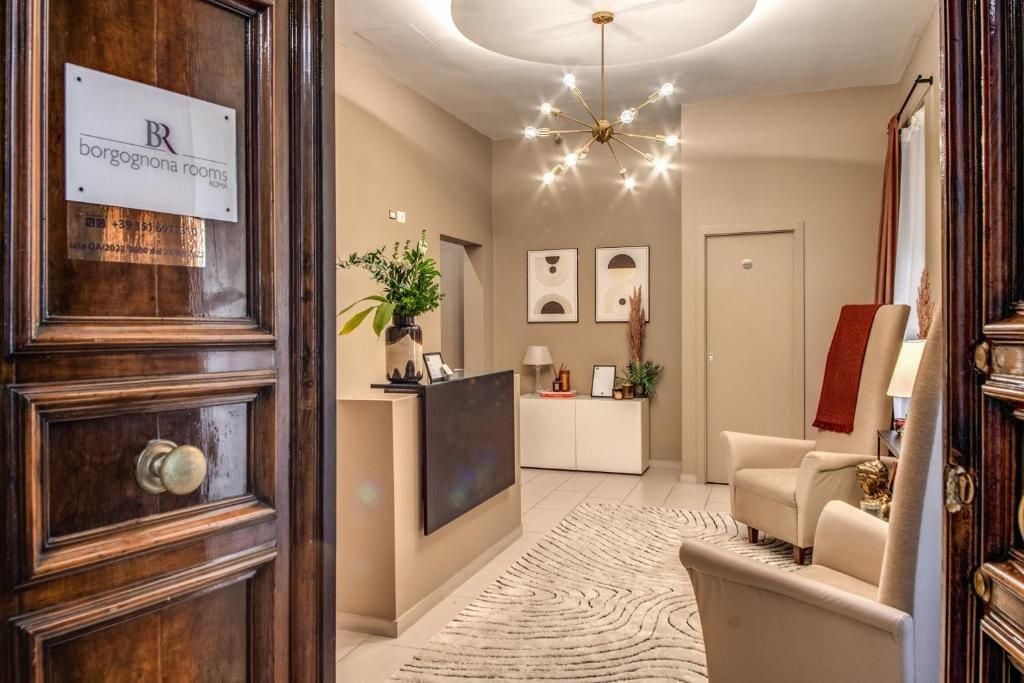 Eine Hotelhalle mit einer Rezeption, einer Sitzecke und einem Chandelier.