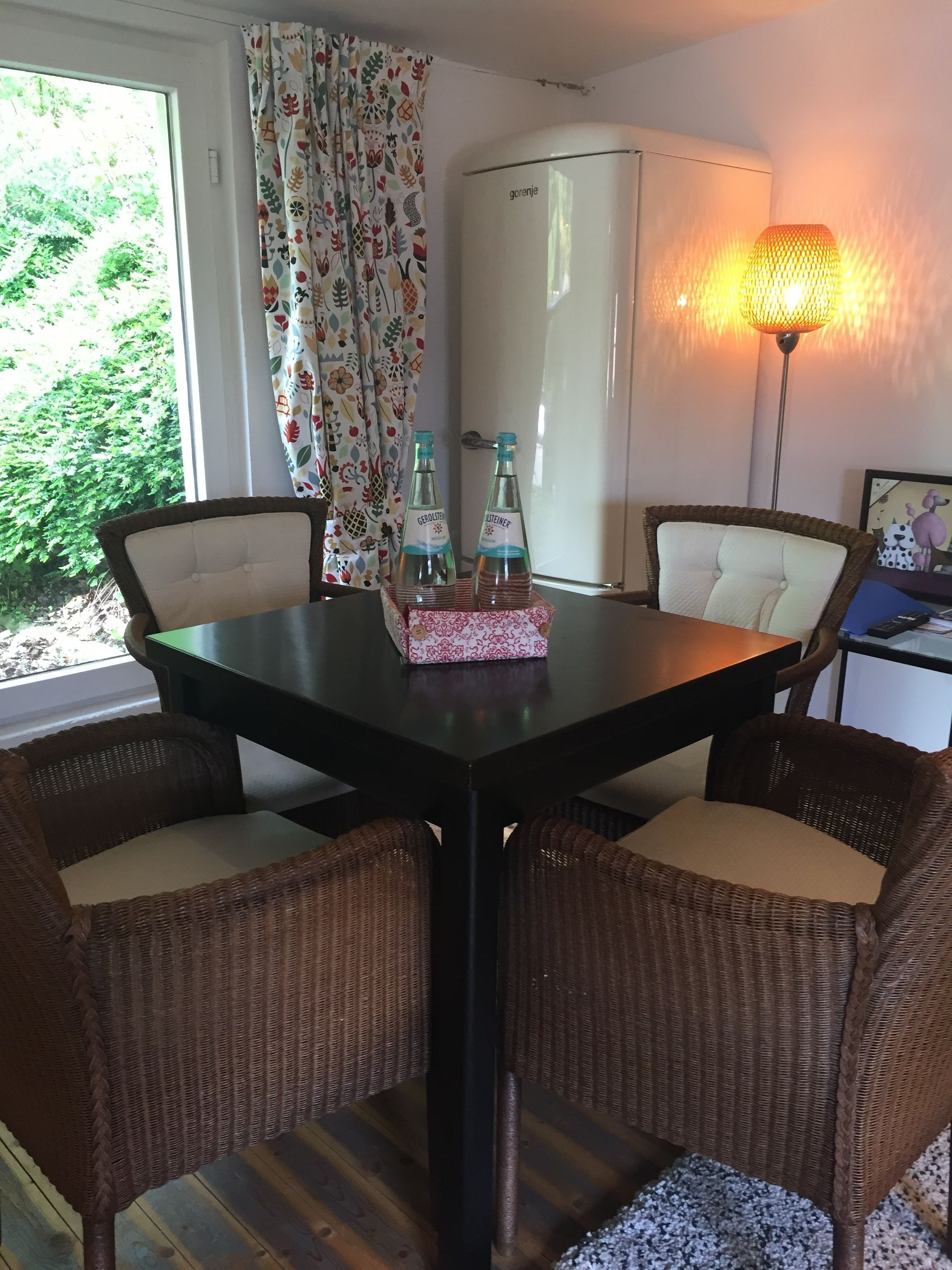 A dining area with a dark table, wicker chairs, and a decorative centerpiece.