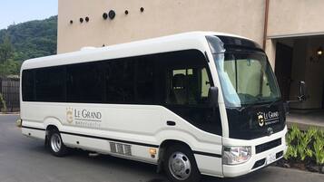 A white and black bus with "Le Grand" branding parked in front of a building.
