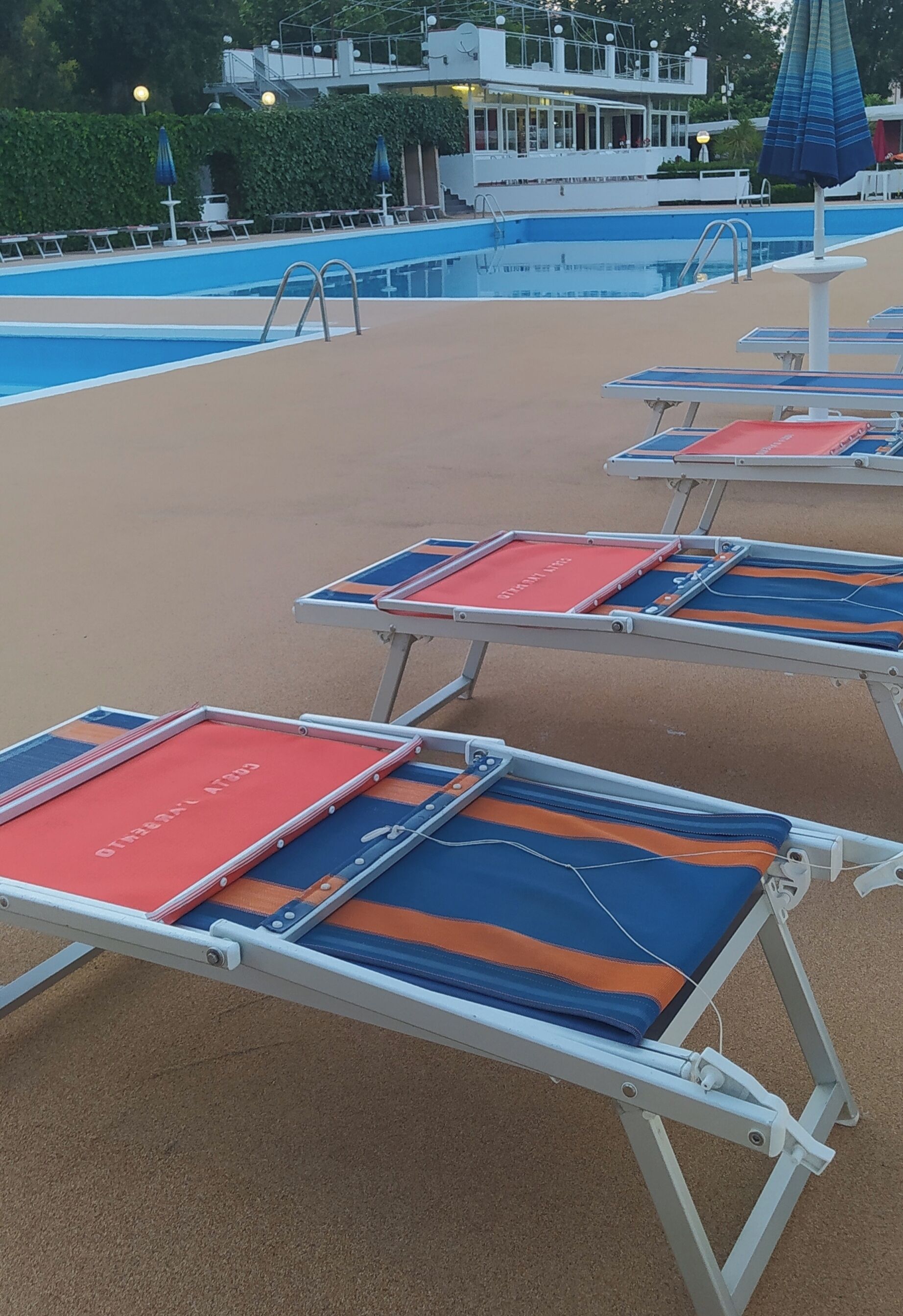 A poolside area with sun loungers and a pool.